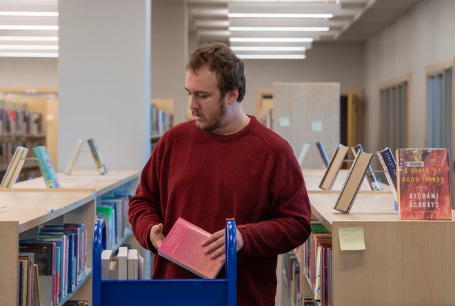 Matt Swanat de Southborough, miembro del personal del mostrador de circulación, coloca libros en la nueva Biblioteca Pública de Marlborough en West Main Street el 27 de septiembre de 2023.