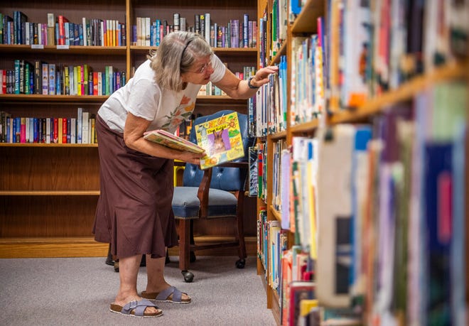 La directora de la biblioteca, Jackie Squires, colocó libros en la biblioteca comunitaria de Stansville el mes pasado.