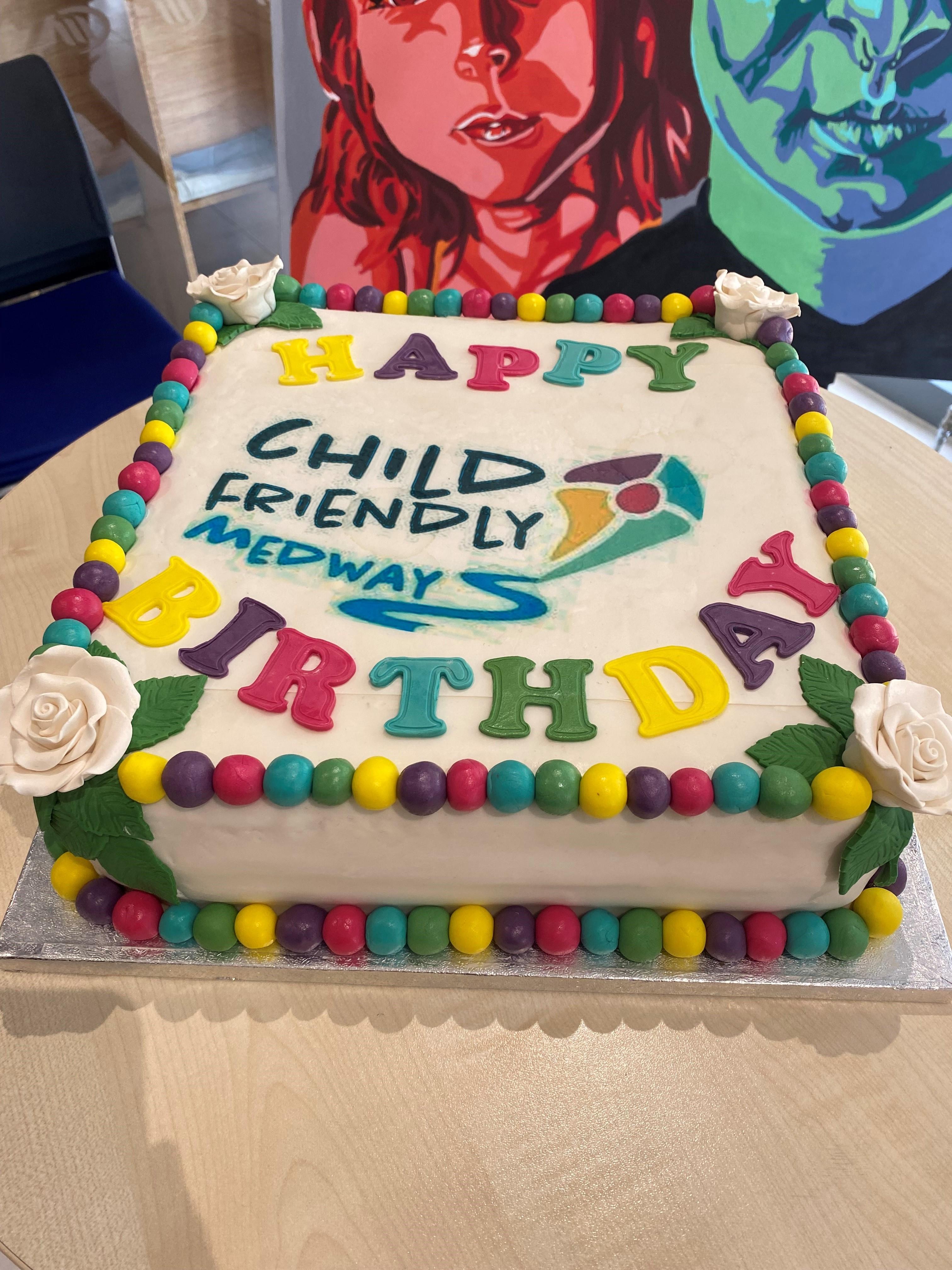 Un pastel de cumpleaños con feliz cumpleaños escrito en letras coloridas