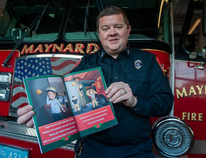 El jefe de bomberos de Maynard, Michael Parr, sostiene su nuevo libro,