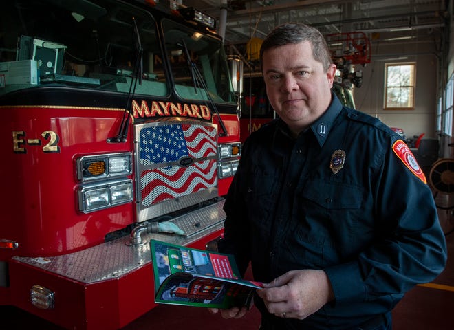 El jefe de bomberos de Maynard, Michael Parr, muestra su nuevo libro sobre seguridad contra incendios.