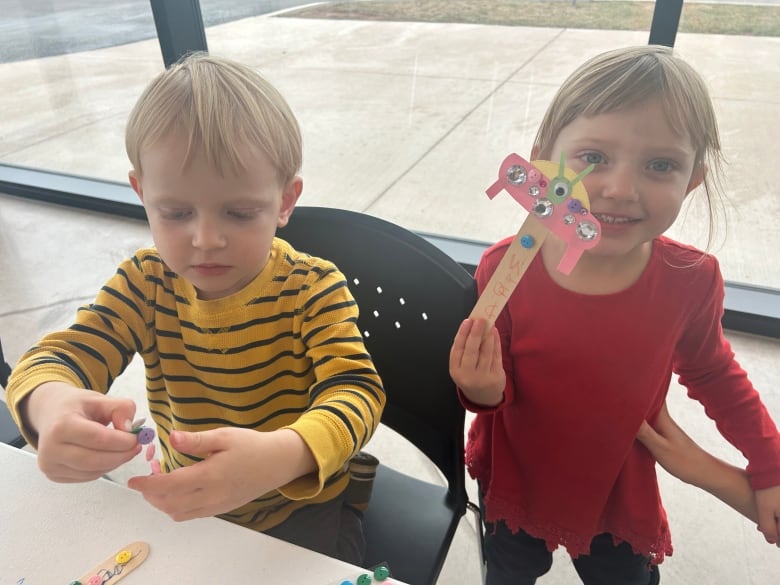 Dos niños están haciendo manualidades. 