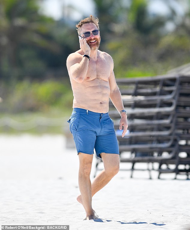 David estaba sin camisa y tomando el sol, llevaba un par de pantalones cortos azules y caminaba descalzo por la playa mientras hablaba por teléfono.