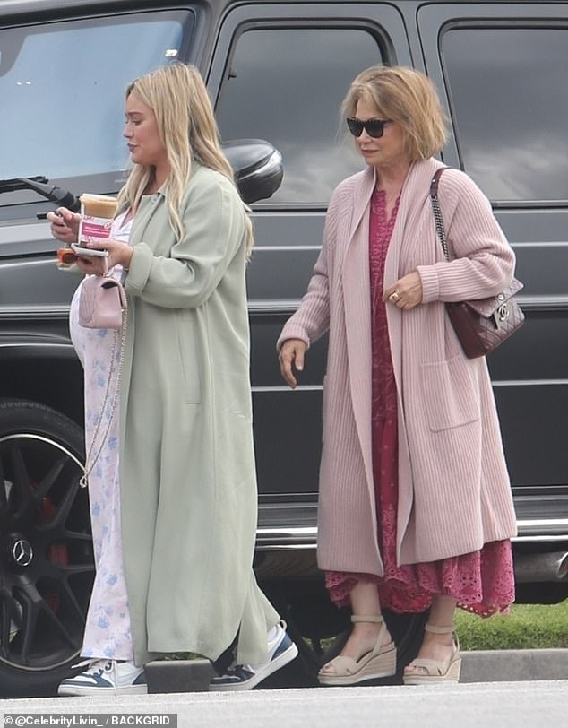 A su lado, su madre lucía un look similar, con un vestido de encaje magenta combinado con un cárdigan largo de punto rosa pálido.