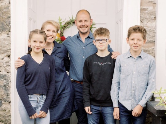 Retrato de la familia de Claire, todos de pie frente a su casa.