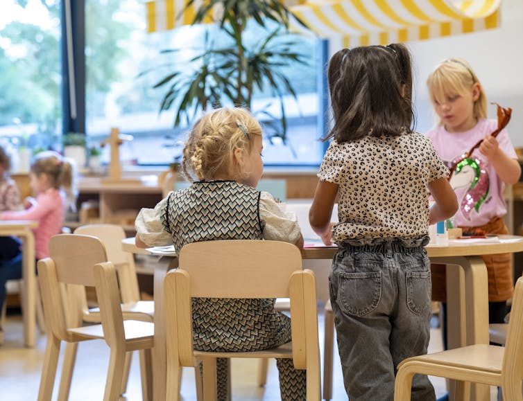 Los niños pequeños están teniendo actividades en mesa de madera en el aula.