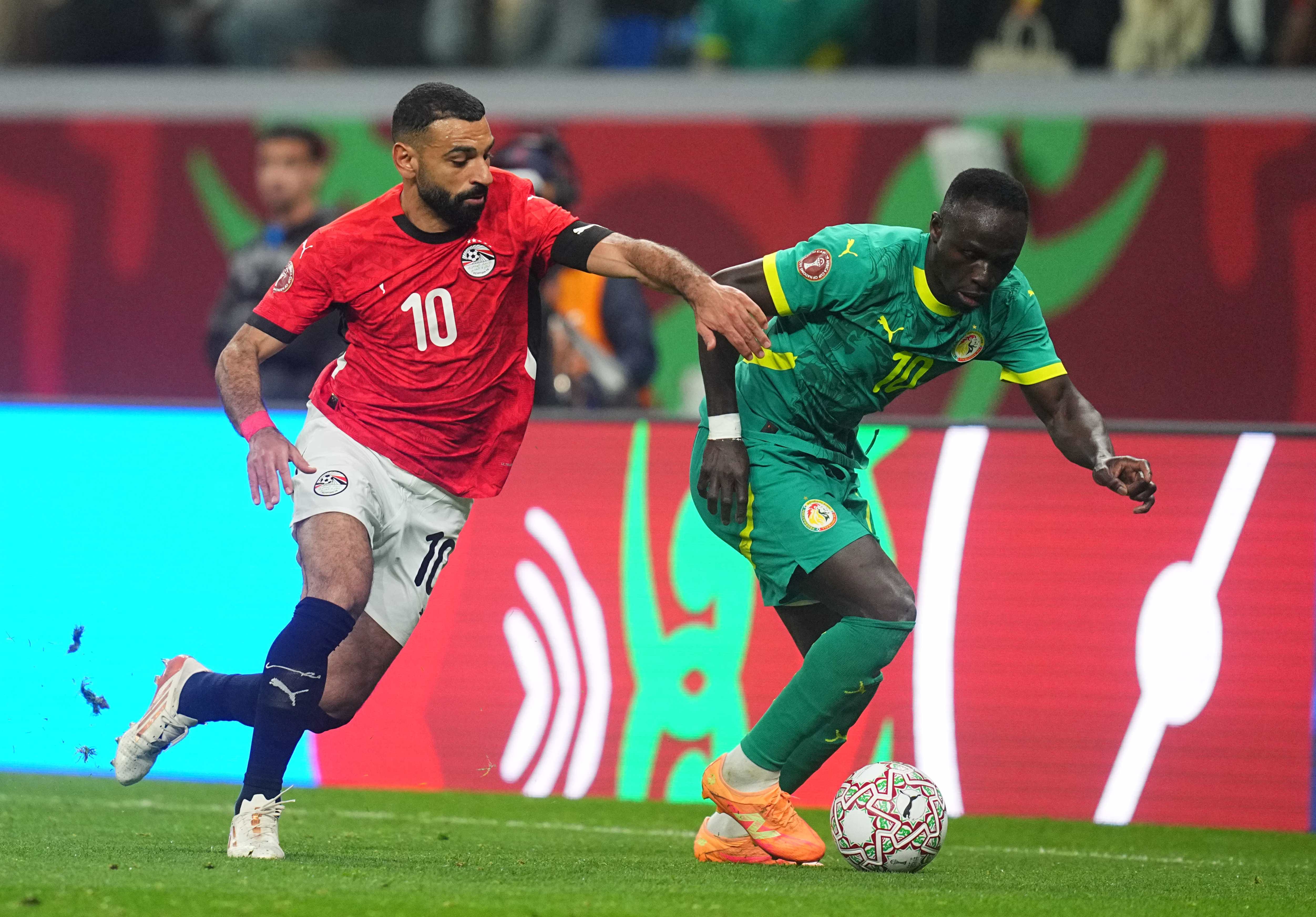 El egipcio Mohamed Salah compite con el senegalés Sadio Mane por el balón durante las semifinales de la Copa Africana de Naciones.