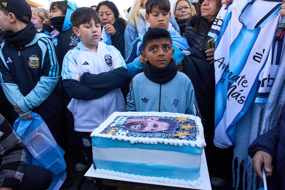 Los chicos se pararon junto a un trozo de tarta que decía en español: